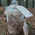 Glass jar with decorative elements on a forest floor