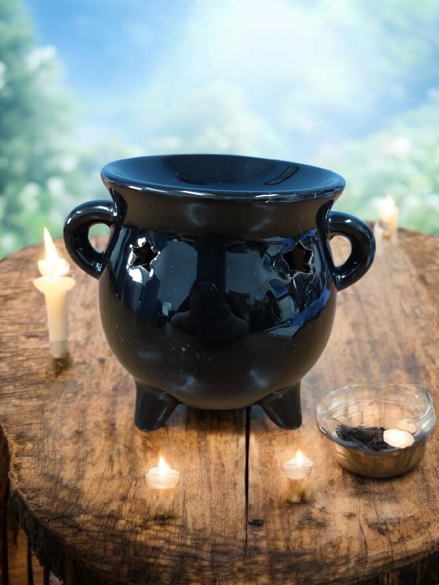 Black cauldron on a wooden surface with candles in the background