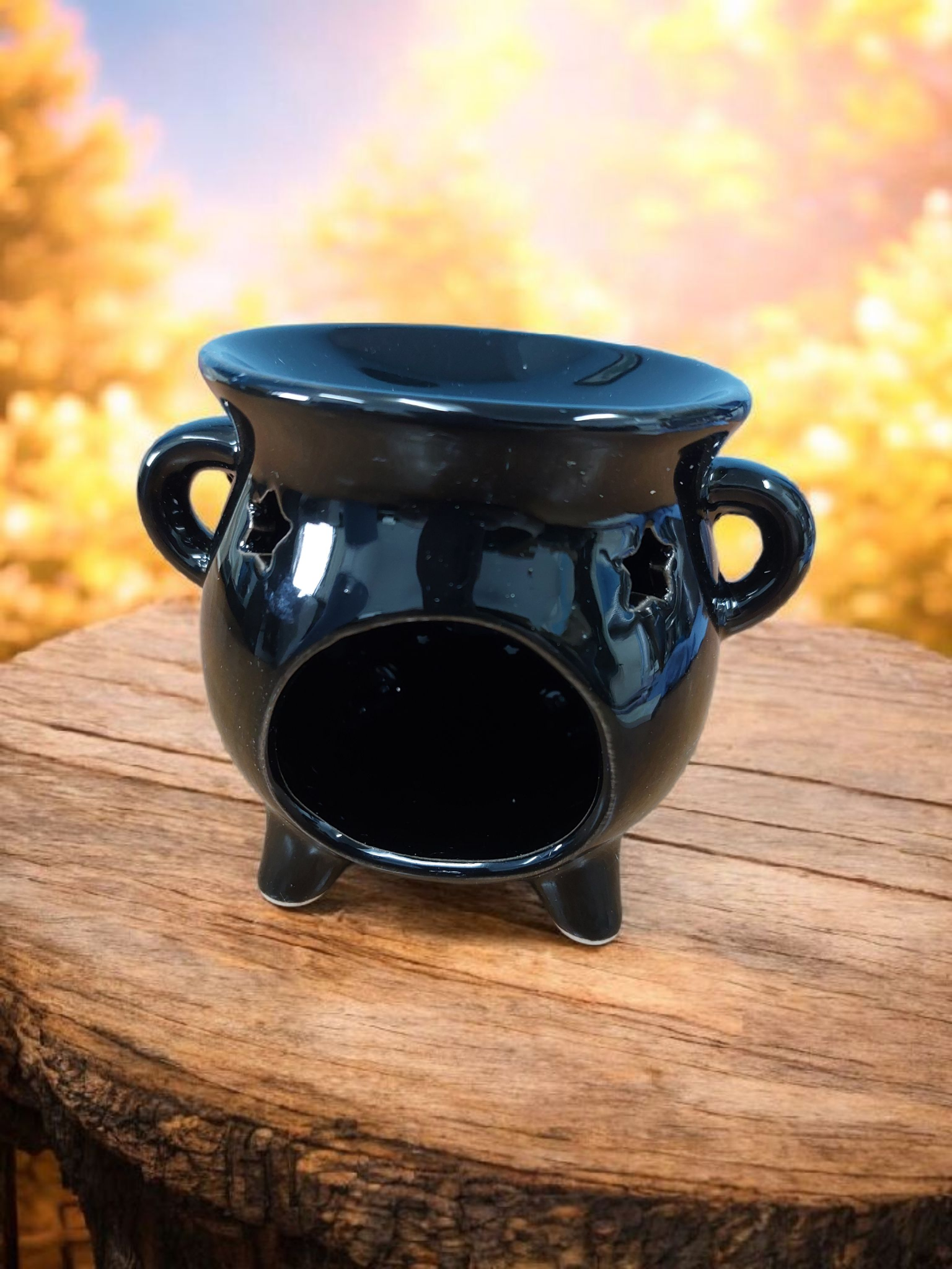 Black ceramic pot with handles on a wooden surface with a blurred natural background