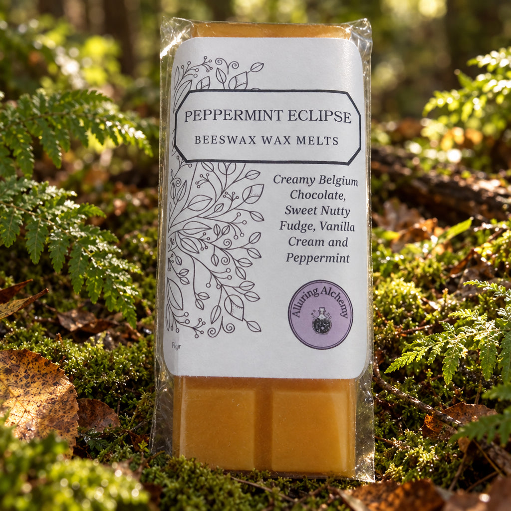 A packaged bar of beeswax melts labeled 'Peppermint Eclipse' by Alluring Alchemy, showing the amber-coloured wax bars through a clear wrapper on a light wood surface.