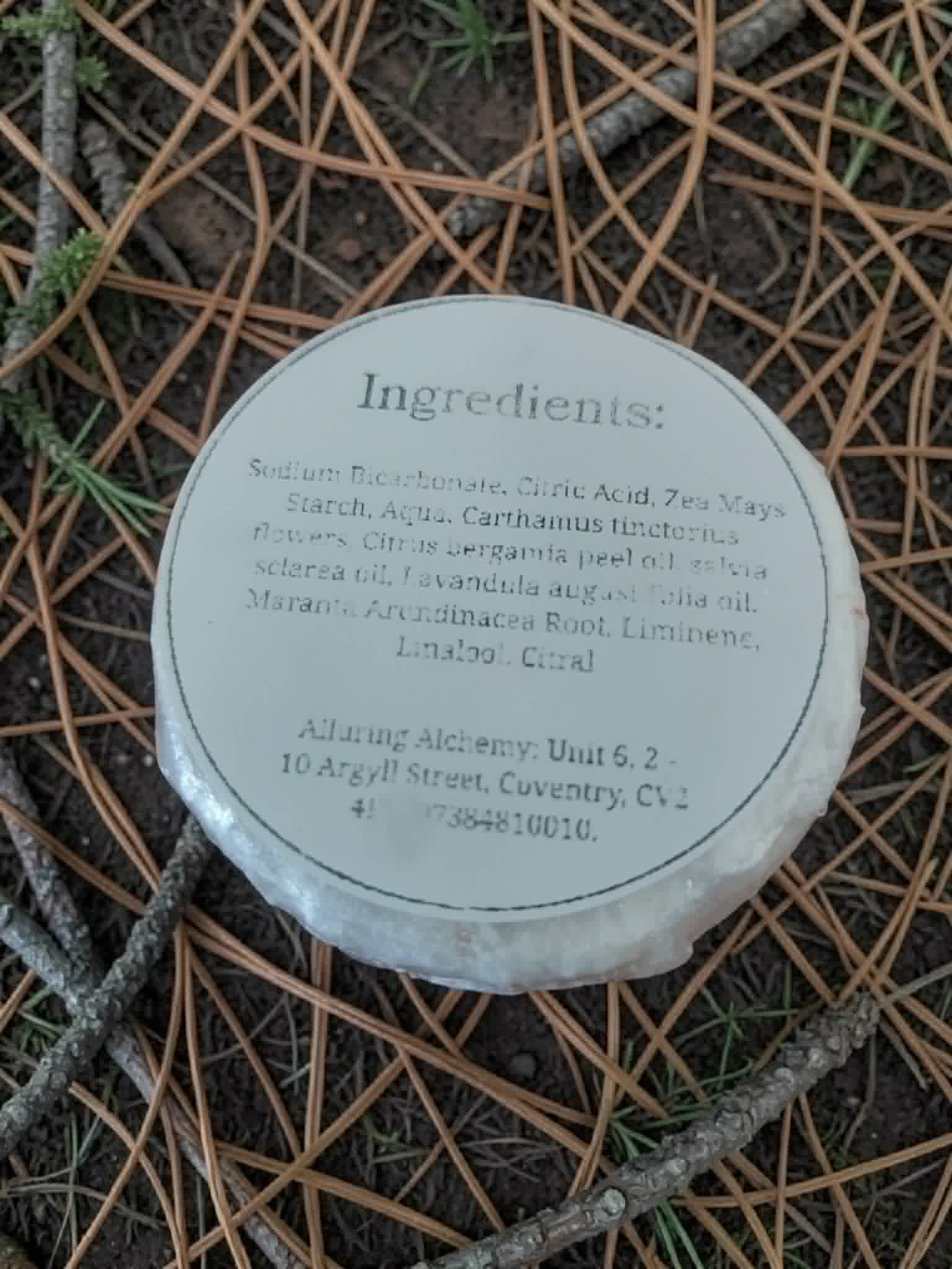 Round container with ingredient list on a textured surface