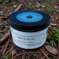 Jar of 'Maple Muse' candle on a natural background with leaves and twigs.