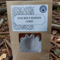 Wax melt burner liner in a brown package with a label on a natural background