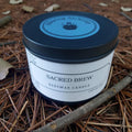 Beeswax candle labeled 'Sacred Brew' on a natural background with leaves and twigs.