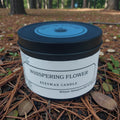 Beeswax candle labeled 'Whispering Flower' on a natural background
